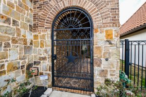 Stone exterior with iron gate featuring star motif in Houston real estate.